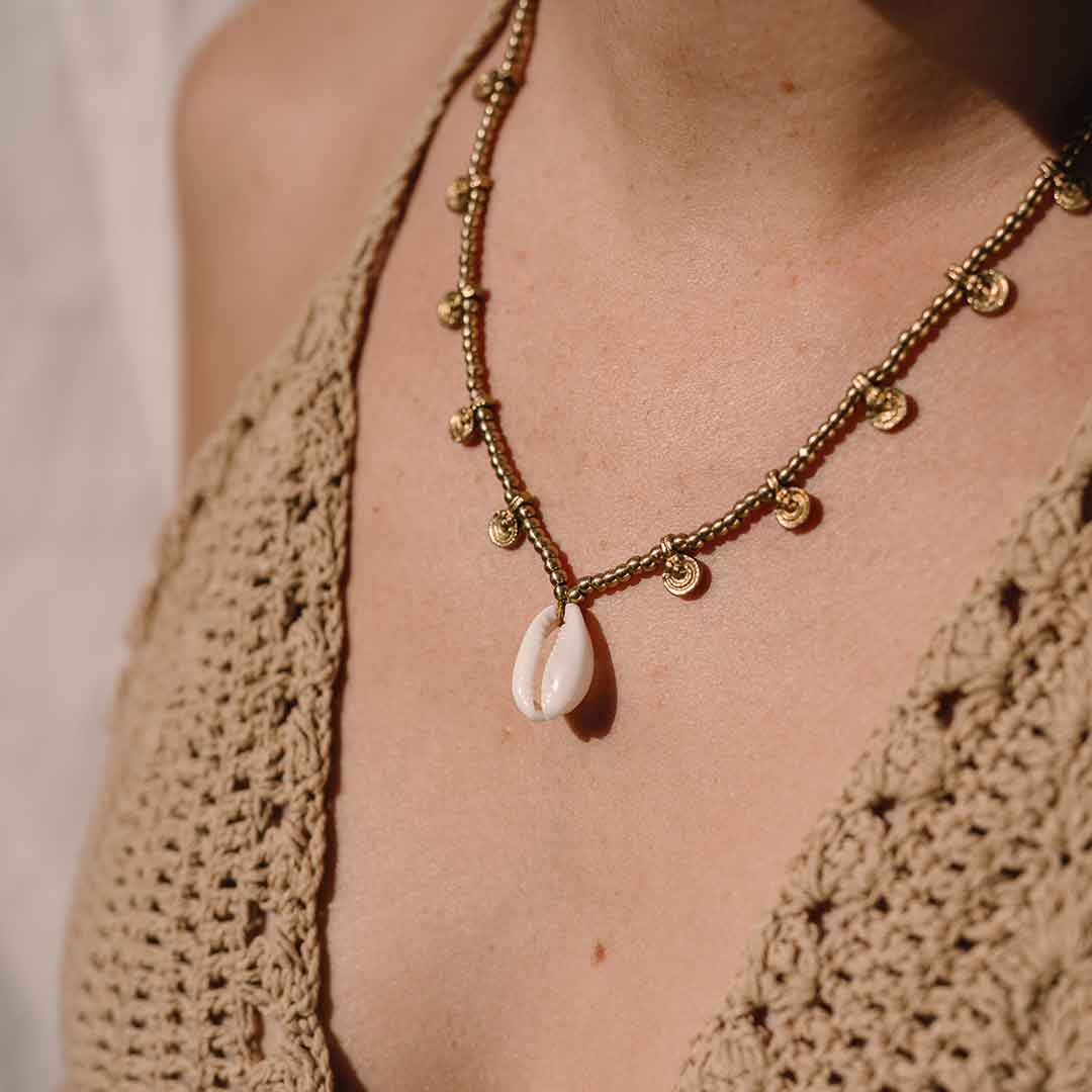 Auf diesem Bild sieht man die Muschelkette am Hals eines Models in Gold.