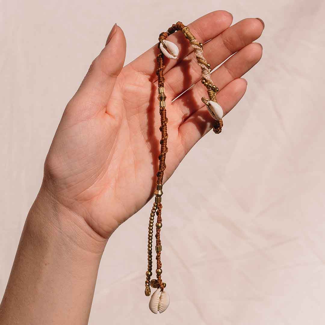 Auf diesem Bild wird die Hairwrap mit Muscheln von einer Handgetragen