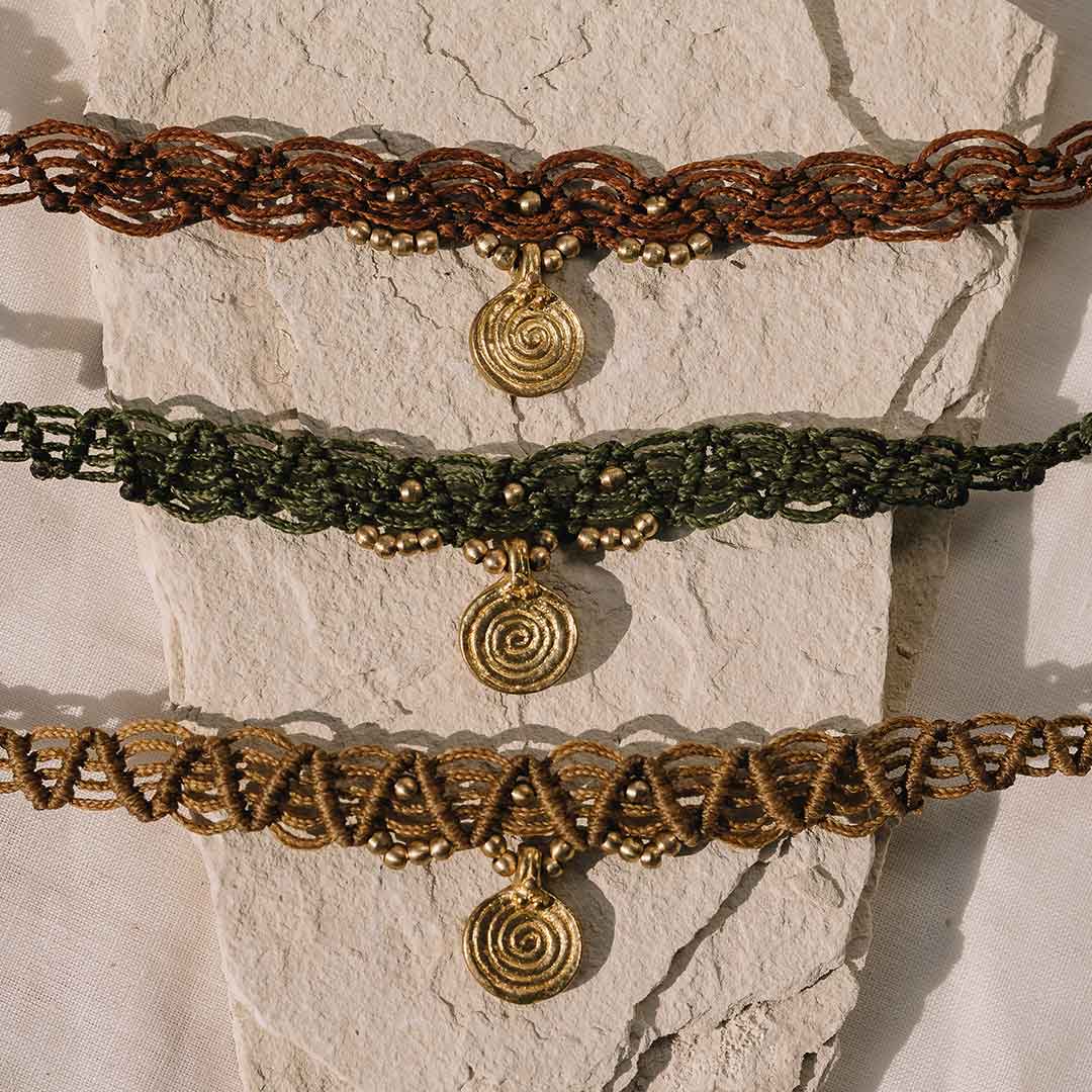 Dieses Bild zeigt den Boho Choker in verschiedenen Farben auf einem steinigem Untergrund.