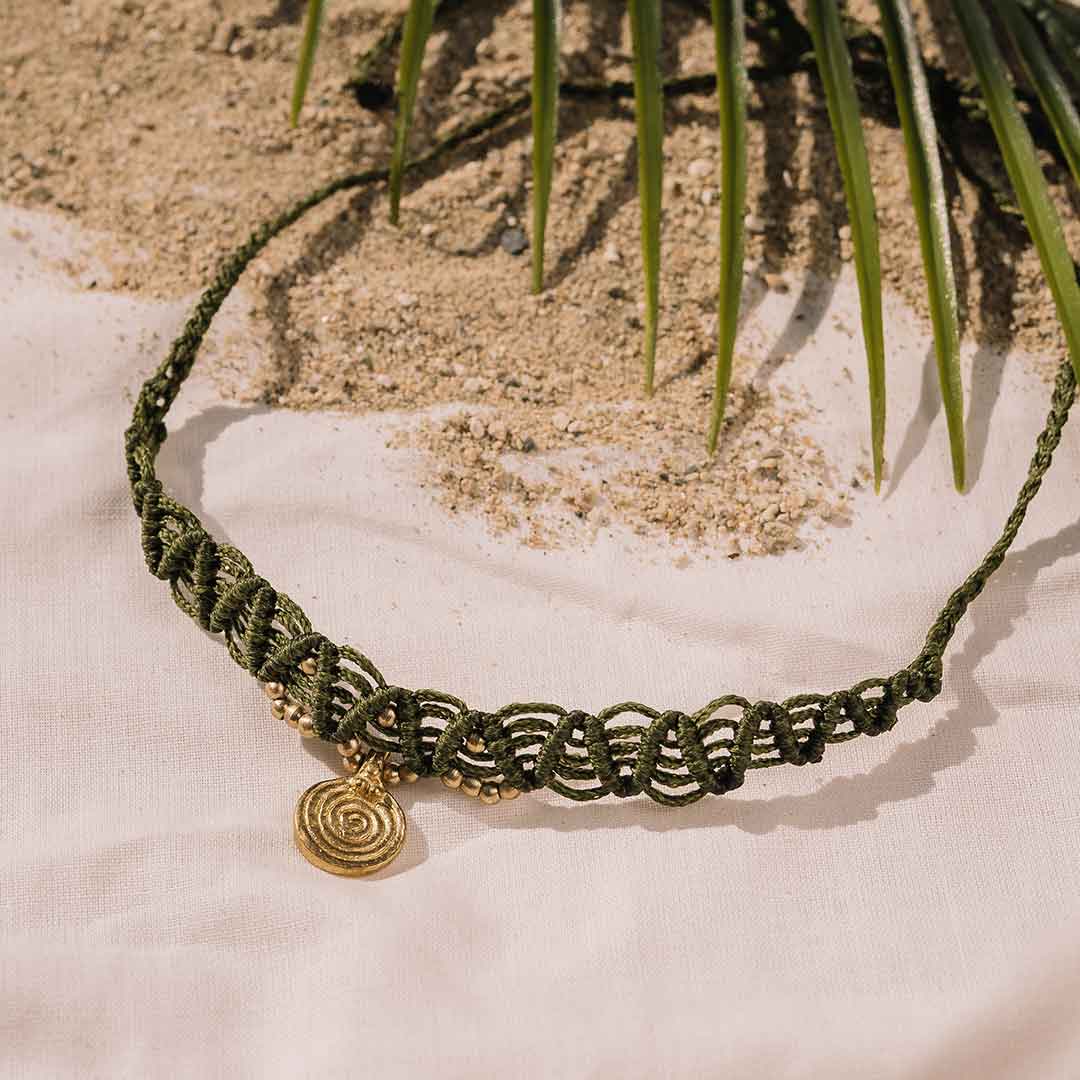 Dieses Bild zeigt einen grünen Boho Choker mit Messing Anhänger.