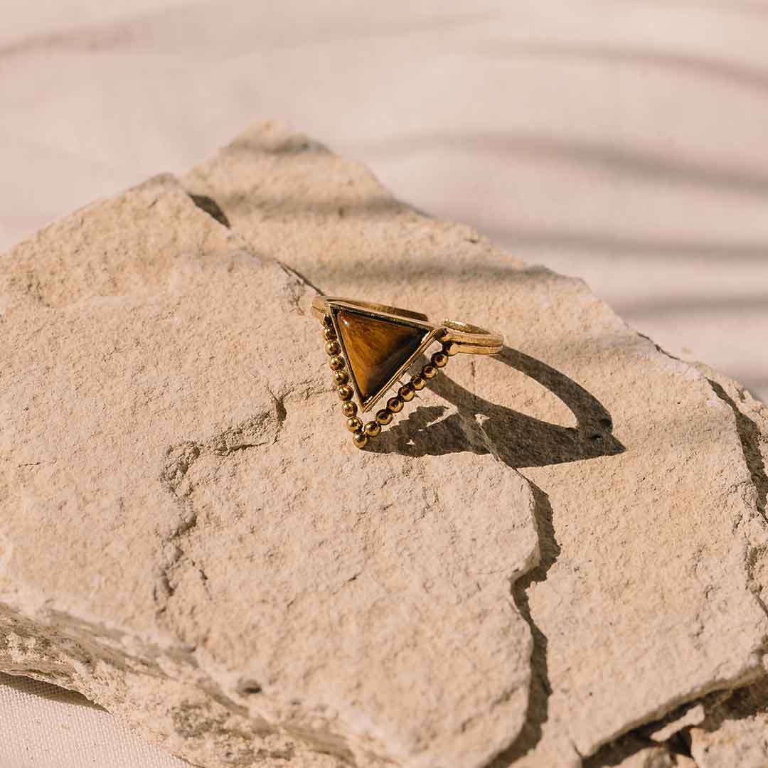 Dieses Bild zeigt den Tigerauge Ring auf einem steinigem Untergrund.