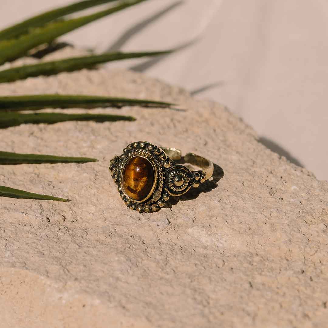 Dieses Bild Zeigt den Boho Ring mit Tigerauge auf einem steinigen Untergrund
