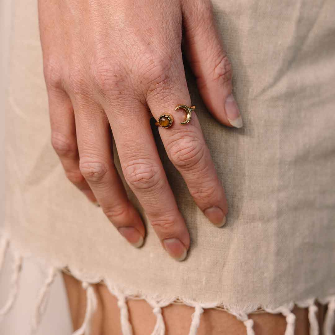 Auf diesem Bild sieht man einen Mond Ring mit Tigerauge in Gold an der Hand eines Models.