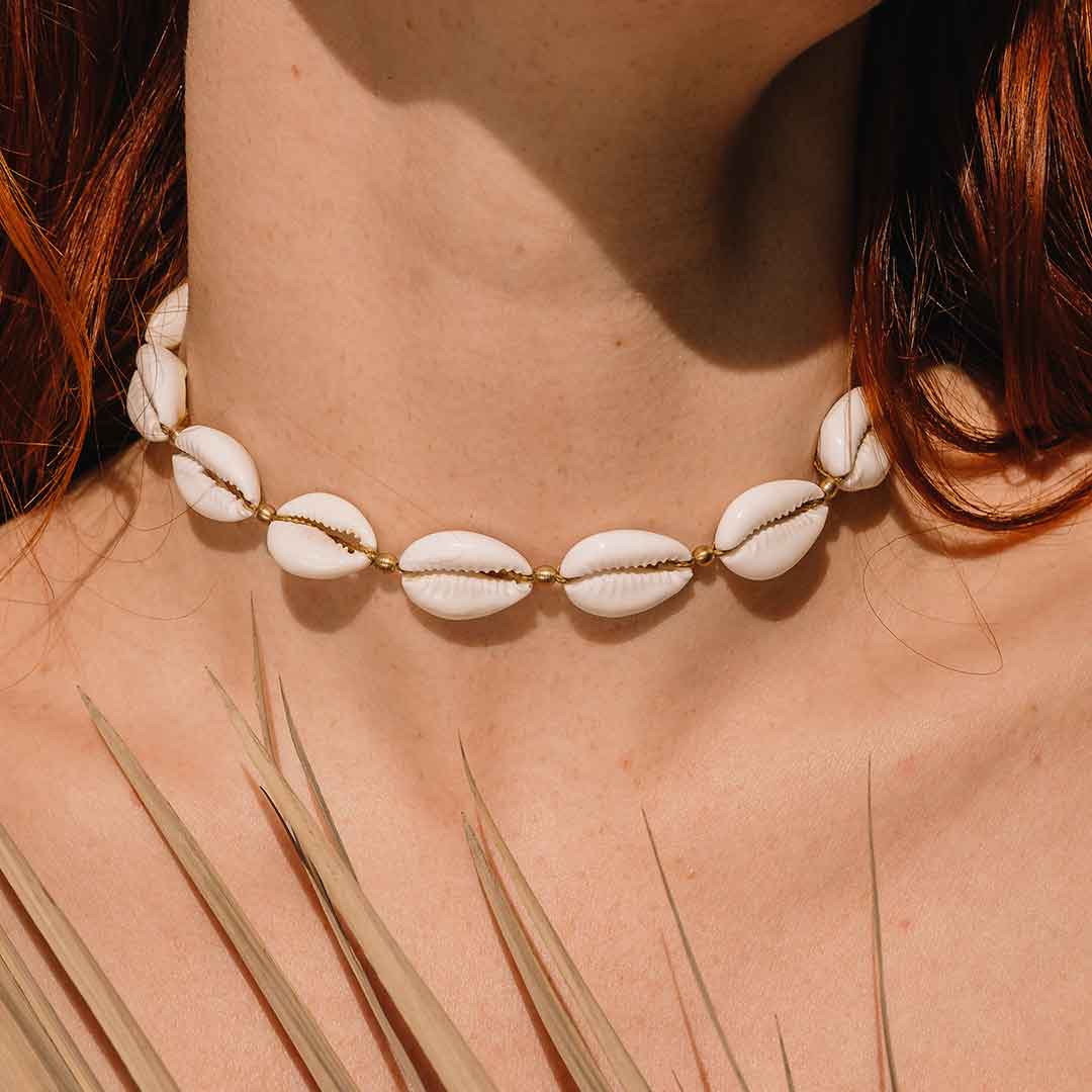 Auf diesem Bild sieht man die Kauri Muschelkette am Hals einer Frau getragen.