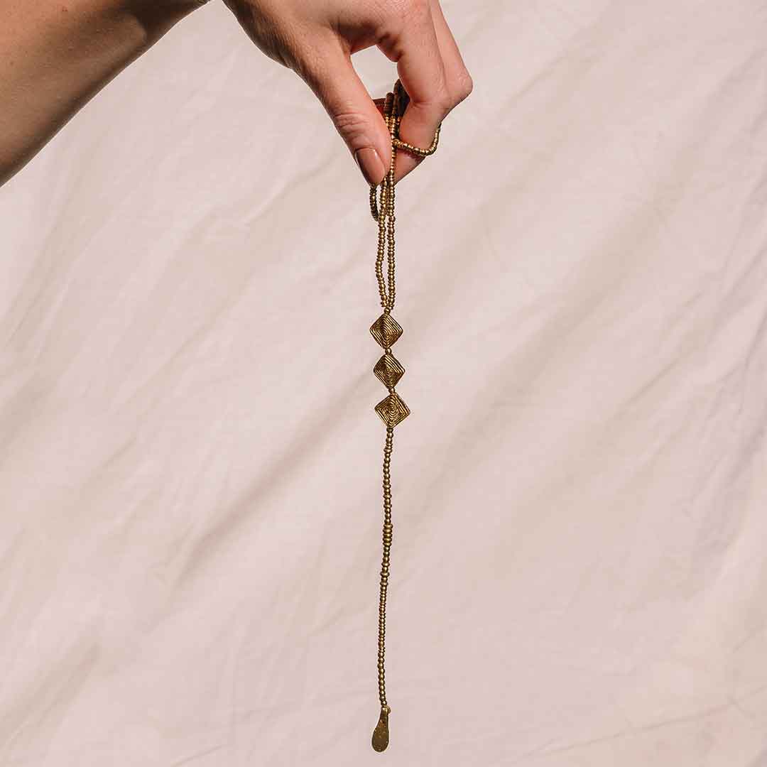 Auf diesem Bild sieht man die goldene Rückenkette von einer Hand gehalten.
