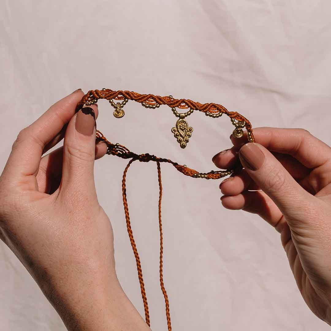 In diesem Bild wird die Halskette aus Makramee von einer Person getragen.
