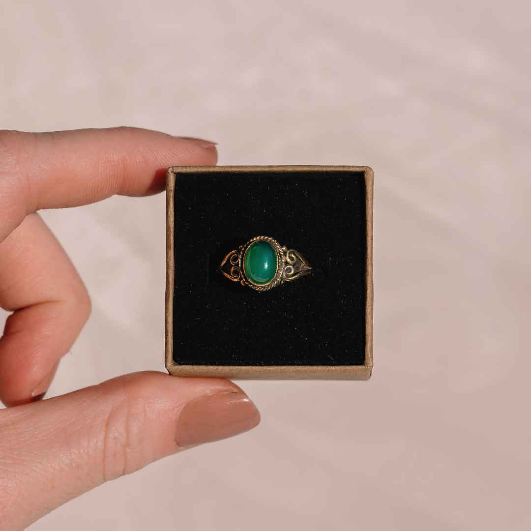 Dieses Bild zeigt die goldenen Ring mit grünem Stein in seiner Verpackung.